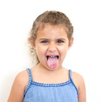 Foto de una niña sacando la lengua. 